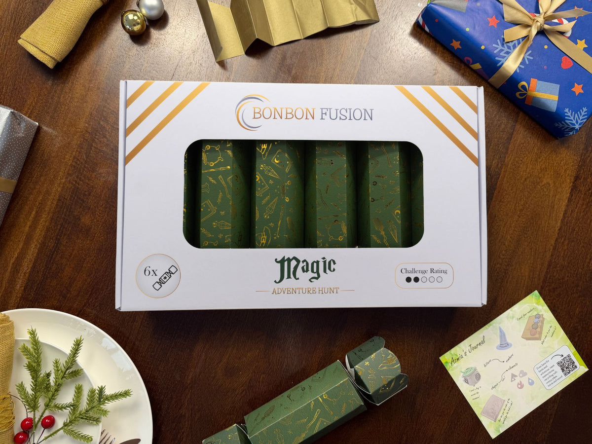 Bonbon Fusion Magic Adventure Hunt pack of six green and gold foil Christmas bonbons on a festive dinner table, with a gold paper crown, a single bonbon and "Azmia's Journal" puzzle clue card